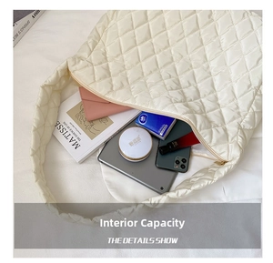 Detailed interior of quilted puffer bag showing large capacity for tablet and essentials