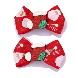 Close-up of red Christmas bow clips with Santa patterns and glittery stocking decor