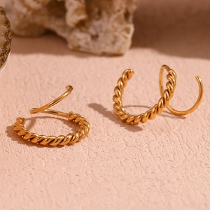 Macro detail of 18K gold plated twisted rope earrings showing high polish texture