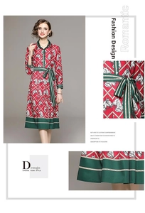 Détail d'une robe rouge imprimée avec motifs de chevaux blancs et ceinture vert foncé
