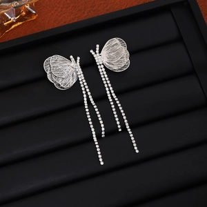 Detailed macro of silver butterfly earrings with sparkling rhinestones and long tassels