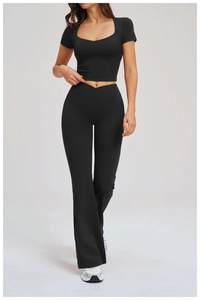 Detail of high-waist yoga pants with V-cross waistband and side pockets in black fabric