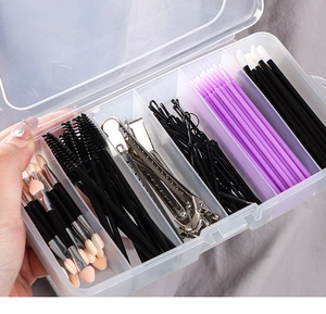 Handgehaltene Ansicht einer klaren Organizerbox mit verschiedenen Kosmetikwerkzeugen
