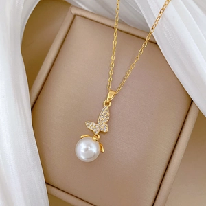 Elegant gold butterfly necklace with shimmering crystals and a white pearl on satin