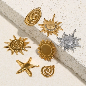 Detail of 18K gold and silver sun, spiral, and starfish charms on a white stone base