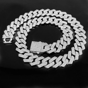 Macro shot of silver hip-hop Cuban chain with triple-row rhinestones on black background