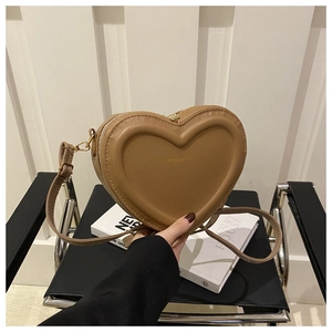Detail of khaki heart-shaped crossbody bag featuring Fashion & Bags logo and gold hardware