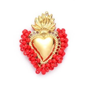 Detailed view of a gold Sacred Heart pendant with red beads and flame top ornament