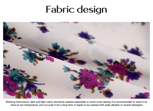 Close-up detail of white fabric with elegant purple and pink floral prints and washing guide
