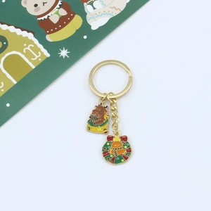 Detailed view of Christmas keychain with enamel reindeer and gingerbread man charms