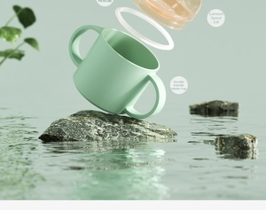 Detail of mint green baby trainer cup featuring ergonomic dual handles and silicone seal