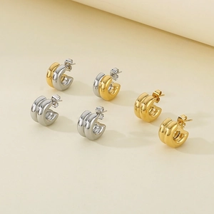 Two-tone gold and silver C-shaped stainless steel earrings in a minimalist hoop design