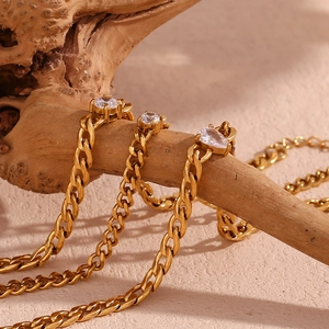 Detail of 18K gold plated chain bracelets with marquise and round cubic zirconia on wood
