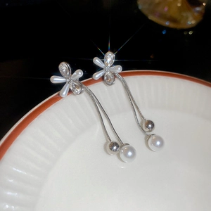 Detail of silver flower tassel earrings with zircons and hanging white pearls