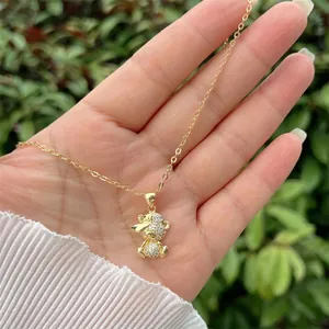 Macro shot of gold-plated bear pendant with sparkling zircons on a delicate chain
