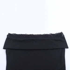 Détail de la dentelle noire élégante sur un haut court à col bénitier chic avec broderies