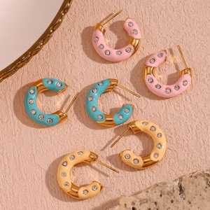 Detail of C-shaped 18K gold-plated enamel earrings with inlaid sparkling crystals