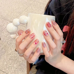 Pink heart press-on nails with glitter rhinestones in a long coffin shape design