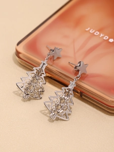Detail shot of silver 3D Christmas tree earrings with star studs and hollow patterns