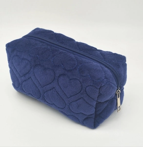 Detail view of blue plush pencil case with stitched heart patterns and zip closure