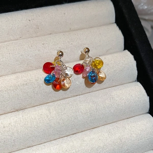 Close-up of vibrant colorful resin beaded cluster earrings in a jewelry box storage tray