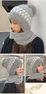 Detailed knit texture of a grey winter hood with ear flaps and a faux fur pom-pom