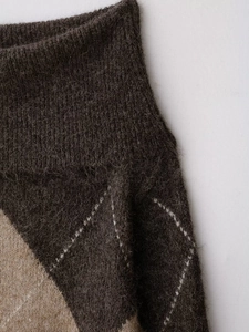 Gros plan détaillé du tricot à losanges marron et beige avec texture douce et duveteuse