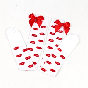 Detailed view of white thigh-high socks featuring red lip prints and decorative bows