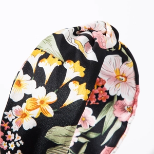 Floral print bohemian wide knotted headband with white and pink flowers on black fabric