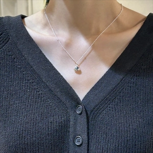 Minimalist 925 sterling silver necklace with grey-green gemstone on a female model