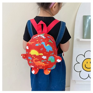 Close-up of red dinosaur backpack with 3D limb details worn by child for size scale