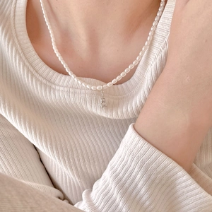 Detail of 925 sterling silver angel bear necklace with elegant cream faux pearls