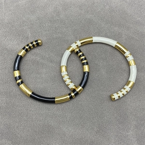 Minimalist black and white enamel open bangles with gold plating in a stylish S-shape layout