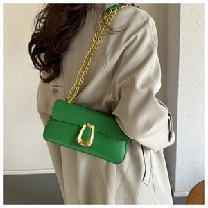 Detail of green PU shoulder bag with gold chain and horseshoe buckle on model back