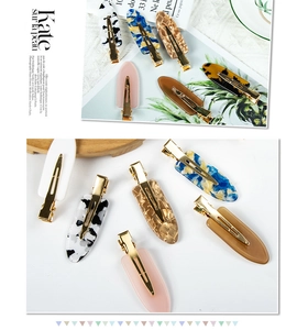 Detail view of colorful tortoise shell and marble texture duckbill hair clips with gold bases