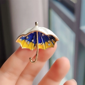 Close-up of star umbrella brooch featuring blue enamel and sparkling rhinestones