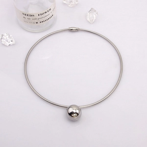 Vue détaillée d'un collier ras du cou argenté avec un grand pendentif boule polie