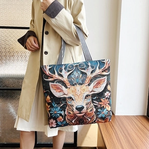 Ethnic 3D embroidered deer canvas tote bag with striped straps held by a model