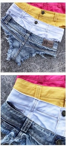 Dettagli di pantaloncini denim colorati con frange pesanti ed etichetta del brand sulla vita