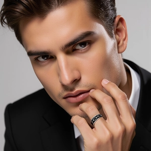 Close-up of a men's vintage titanium steel ring with black chain patterns and oil finish