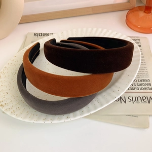 Detail of wide velvet headbands in dark brown, orange-brown, and smoke gray colors