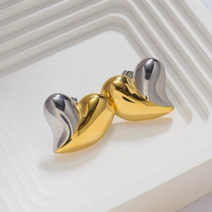 Detailed close-up of two-tone heart stud earrings in polished gold and silver finish