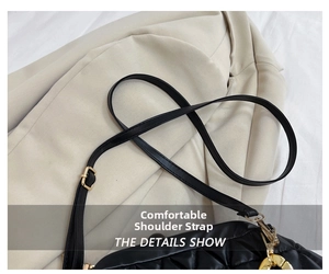 Detail view of black quilted crossbody bag with adjustable strap and gold metal buckle