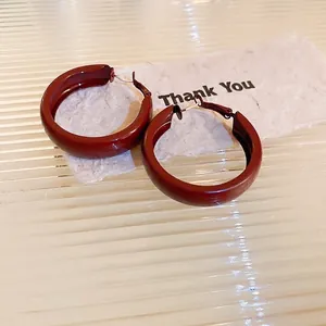 Minimalist deep red round hoop earrings with a smooth glossy lacquer metal finish