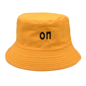 Detailed view of yellow cotton bucket hat with black letter embroidery and stitched brim