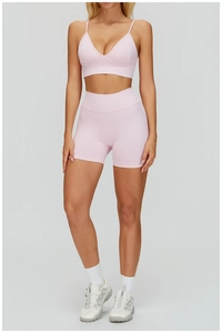 Détail d'un ensemble de yoga côtelé rose clair avec soutien-gorge de sport et short taille haute