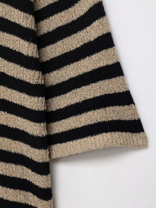 Détail de la manchette en tricot à rayures horizontales noires et dorées