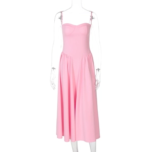 Detail view of pink strap dress featuring fitted waist and voluminous pleated skirt