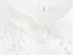 Detailed close-up of a white lace blouse featuring a stand collar and button closure