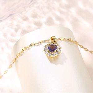 Gold titanium steel necklace with a purple zircon floral pendant on a beige stand